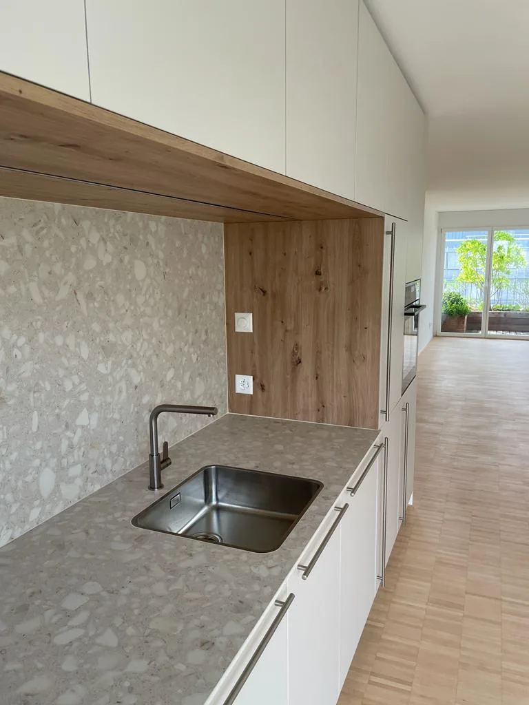 Gesprenkelte Arbeitsplatte mit Spüle in einer Nische aus Holz