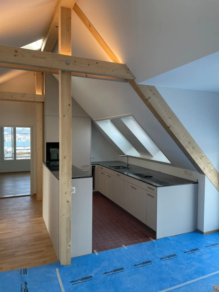 Küche unter der Dachschräge mit sichtbaren Holzbalken