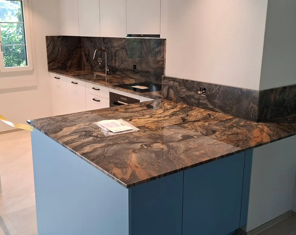 Küche mit gemaserter Arbeitsplatte aus Naturstein und blauen Fronten